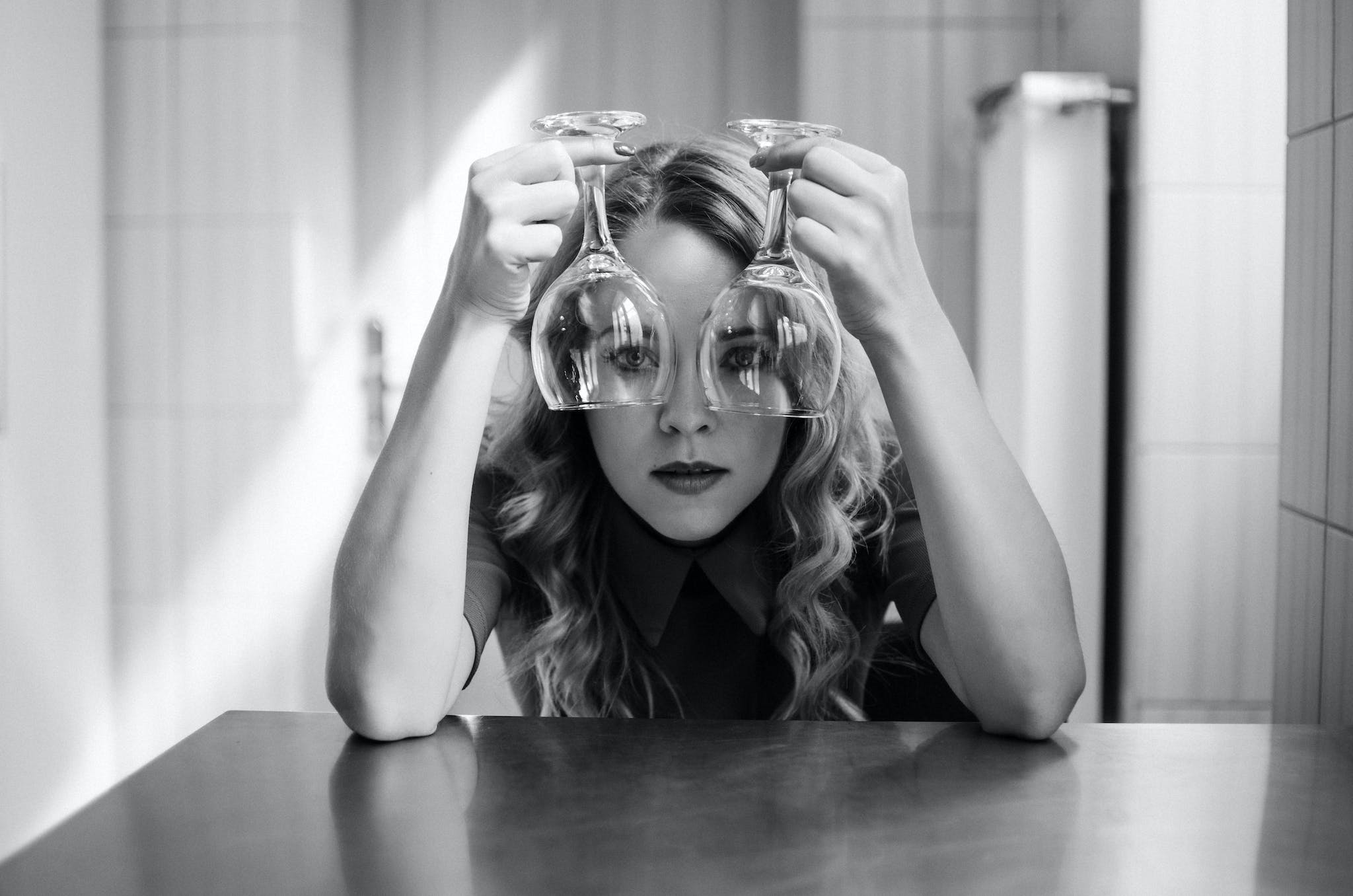 Black and white of young covered female touching head with hand and pensively looking away
